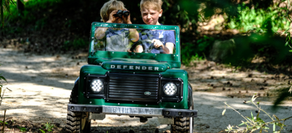 2 boys driving a mini Land Rover