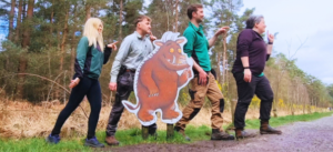 Rangers in the forest posing with a picture of the Gruffalo