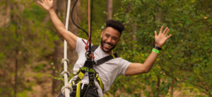 Man on zip wire in forest smiling