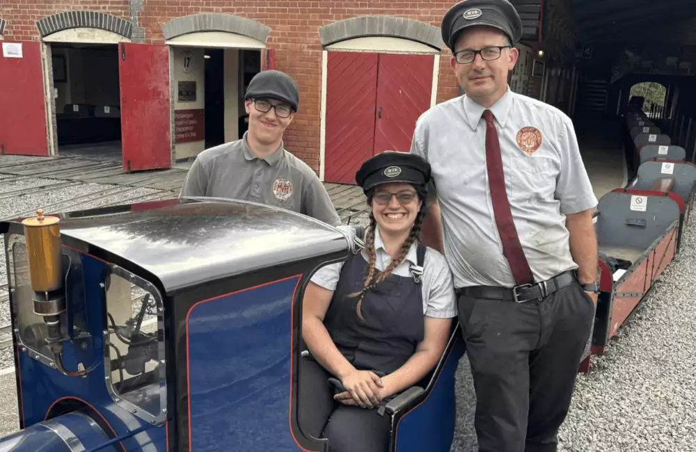 Moors Valley Railway Staff smiling whilst sitting behind Steam Locomotive