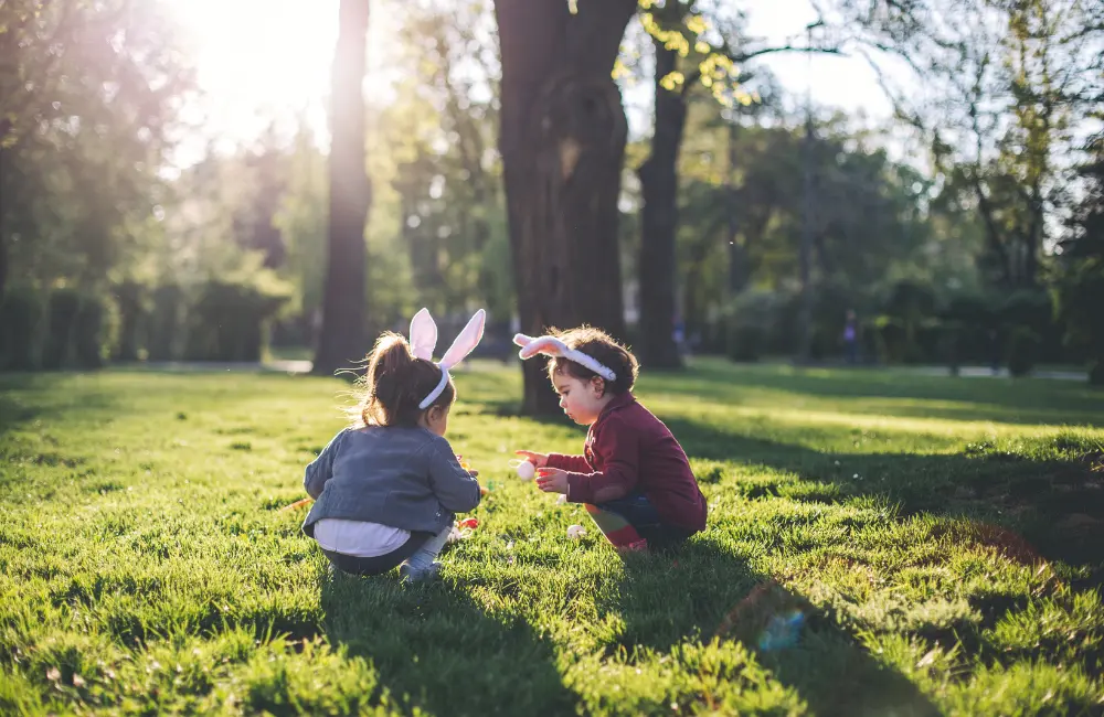 Children with bunny ears playing in grass