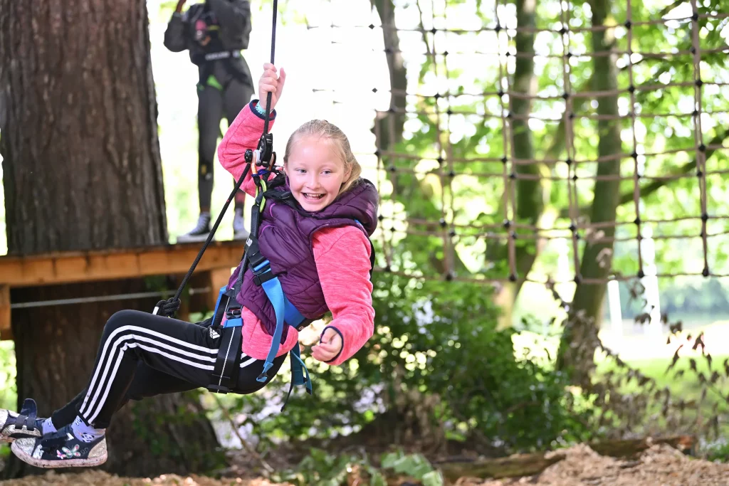 Girl zip wiring through forest