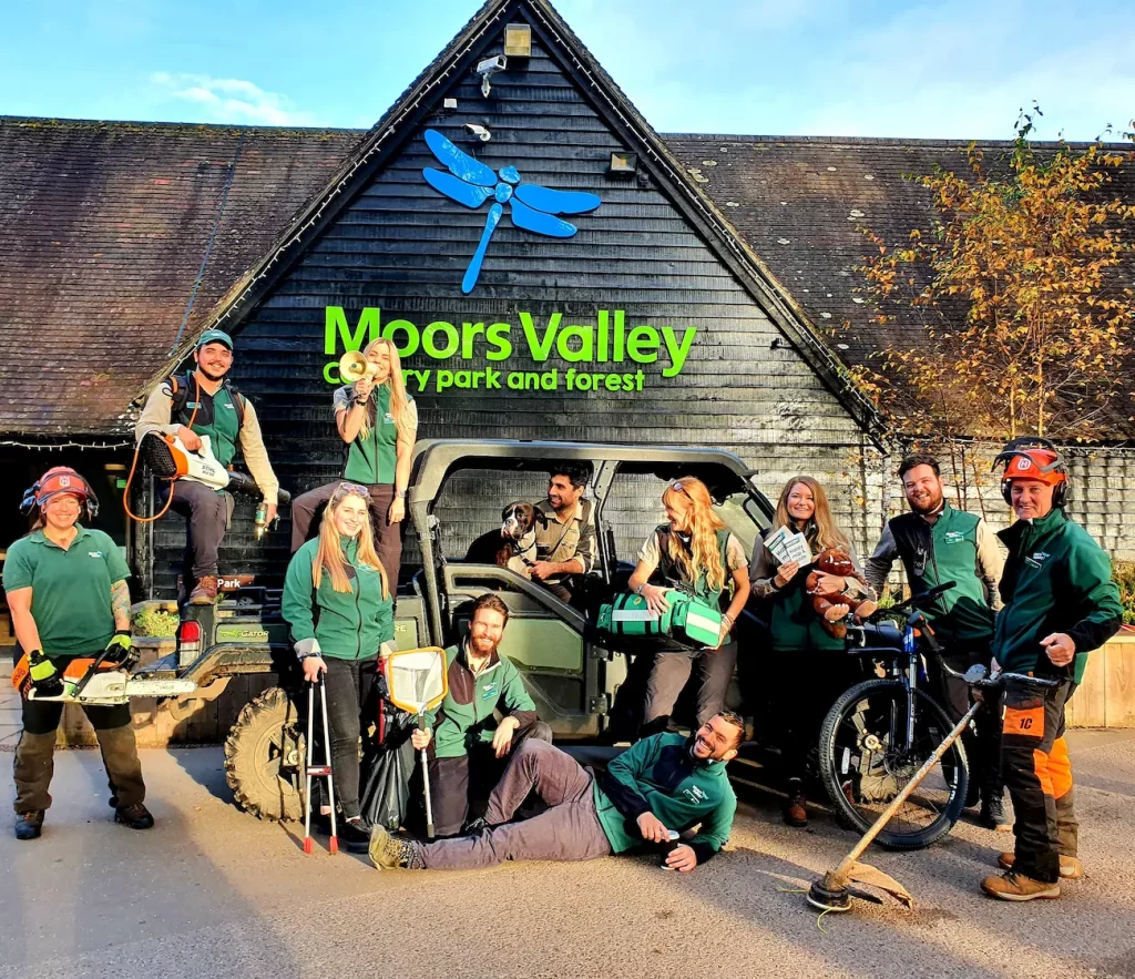 A group of rangers stand and sit around a vehicle outside the Moors Valley Country Park and Forest Visitor Centre.