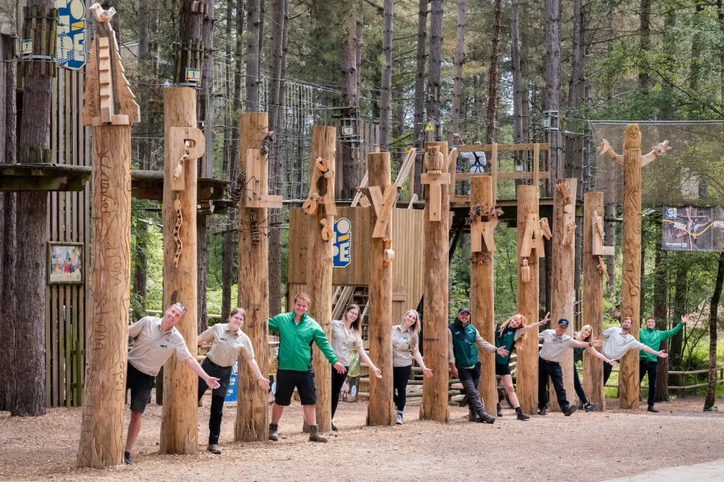 A group of rangers stand beside the Play Trail sign at Moors Valley.